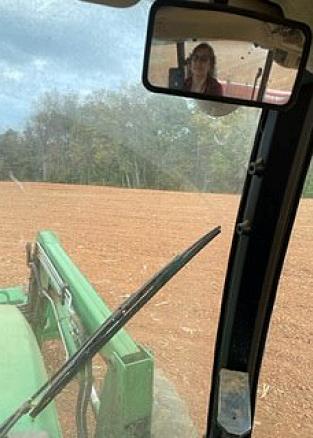 Cathy in the rear view mirror of the tractor as she cultivates the field 12 weeks after mitral valve surgery..
